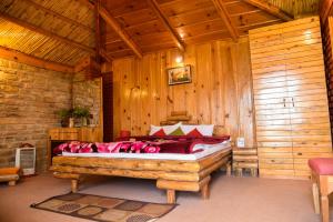 a bedroom with a bed in a wooden room at Trinetra Orchards in Mukteswar