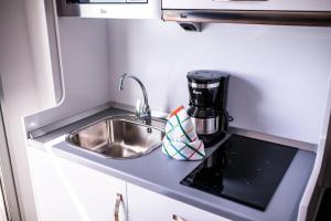a kitchen with a sink and a coffee maker on a counter at IG Nachosol Atlantic & Yaizasol by Servatur - Adults Only in Puerto Rico de Gran Canaria