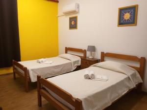 a room with two beds and a yellow wall at HI Faro – Pousada de Juventude in Faro