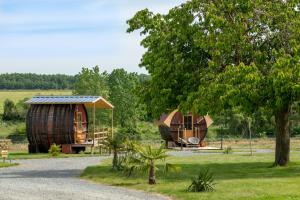 ein paar Cottages auf einem Feld mit einem Baum in der Unterkunft Les "JOLY" Foudres in Vaudelnay