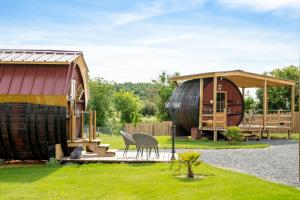 uma casa de hobbit com um barril ao lado de um barracão em Les "JOLY" Foudres em Vaudelnay