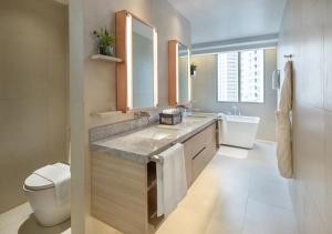 a bathroom with a sink and a toilet at Brittany Hotel BGC in Manila