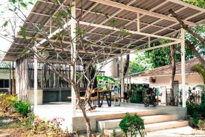 a wooden pergola with a table in a yard at Green tree house 度假屋 in Ko Chang