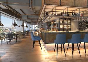 a restaurant with blue chairs and a bar at Brittany Hotel BGC in Manila