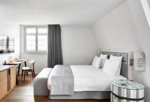 a bedroom with a large white bed and a desk at Pavillon REGENT PETITE FRANCE in Strasbourg