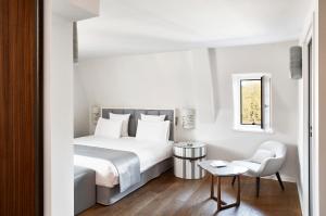 a bedroom with a white bed and white walls at Pavillon REGENT PETITE FRANCE in Strasbourg