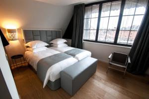 a bedroom with a large bed and large windows at Pavillon REGENT PETITE FRANCE in Strasbourg