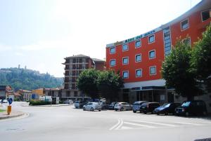 a city street with cars parked in a parking lot at Hotel Alpi Del Mare in Mondovì