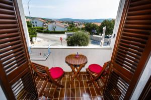a balcony with a table and chairs and a view of a street at Rooms Mimi in Krk +16 photos
