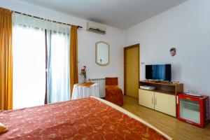 ein Hotelzimmer mit einem Bett und einem TV in der Unterkunft Rooms Mimi in Krk