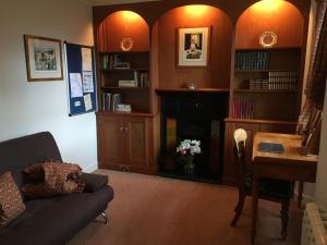 a living room with a fireplace and a table at Castle Peroch in Dunkeld