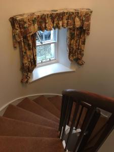a stairway with a window with curtains on it at Castle Peroch in Dunkeld