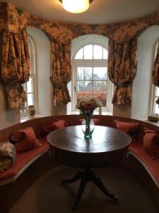 a living room with a table and a window at Castle Peroch in Dunkeld