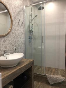 a bathroom with a sink and a glass shower at Apartment on Bratskaya 6 in Minsk