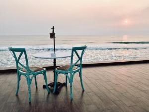 einen Tisch und zwei Stühle neben dem Meer in der Unterkunft My Resort Hua Hin A304 in Hua Hin