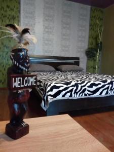 a zebra print bed in a room with a table at Always at home - Apartments №2 at Klimasenko 11 block 7 in Novokuznetsk