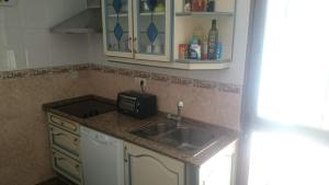 a kitchen with a sink and a microwave at Isabelita in Rota