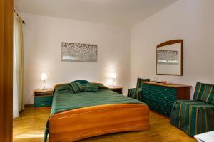 ein Schlafzimmer mit einem Bett und zwei Stühlen darin in der Unterkunft Rooms Mimi in Krk
