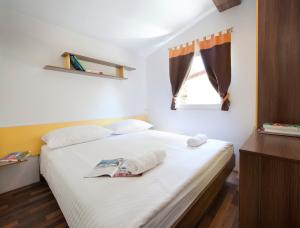 a bedroom with a white bed with a window at Holiday Resort Medveja - by Liburnia Hotels & Villas in Medveja
