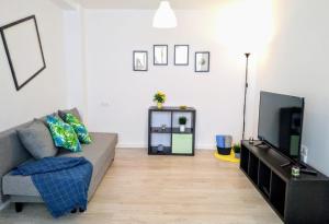 a living room with a couch and a tv at Islas Canarias Apartment in Valencia