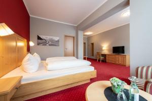 ein Hotelzimmer mit einem Bett und einem Schreibtisch in der Unterkunft Hotel Vollmann in Weilheim in Oberbayern