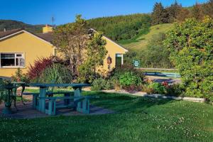 una mesa de picnic en el césped frente a una casa en The Gap Lodge B&B, en Donegal