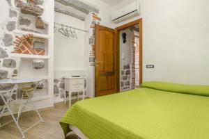 a bedroom with a green bed and a table at Room Tortoli' in Tortolì