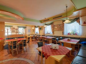 um restaurante com mesas e cadeiras de madeira e janelas em Dorf-Zimmer Mirth em Eltendorf