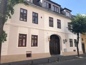 een wit gebouw met een zwarte deur op een straat bij Gothic Central Sibiu in Sibiu