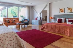 una camera con due letti, un divano e un tappeto di Capim Dourado Apartments Cedofeita a Porto