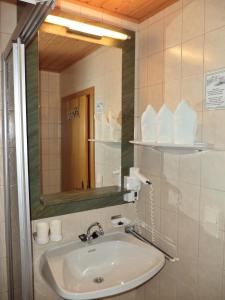 a bathroom with a sink and a mirror at Alpenhof Schwaiger - Hotel Garni in Mühlbach am Hochkönig