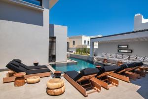 a living room with a swimming pool and furniture at Uma Ray Suites in Fira