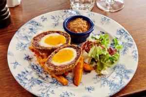 a plate of food with eggs and vegetables on a table at The Jug And Bottle in Heswall