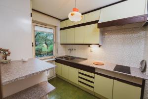 uma cozinha com armários amarelos e brancos e uma janela em Apartmaji Retro em Spodnje Gorje