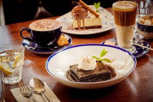 a table with plates of desserts and cups of coffee at The Jug And Bottle in Heswall