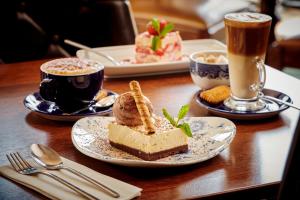a table with two plates of food and two cups of coffee at The Jug And Bottle in Heswall