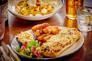a table with a plate of food and a bowl of salad at The Jug And Bottle in Heswall
