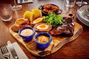a plate of food with meat and eggs on a table at The Jug And Bottle in Heswall