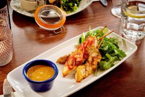 a plate of food with chicken and salad on a table at The Jug And Bottle in Heswall