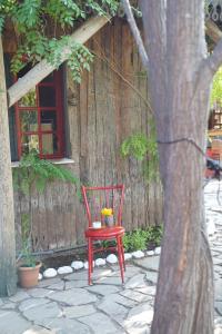 a red chair sitting in front of a tree at Kadir's Family House in Olympos