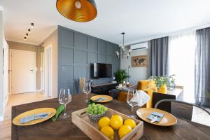 a kitchen and living room with a table with fruit on it at Apartamenty Flat White Obywatelska 47AB in Zielona Góra