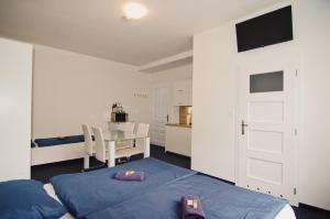 Cet appartement comprend une chambre avec un lit et une table ainsi qu'une cuisine. dans l'établissement APARTHOTEL VÍTKOVICE, à Ostrava