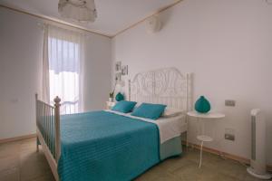 ein weißes Schlafzimmer mit einem Bett und einem Fenster in der Unterkunft Bio B&B Vivere la Vita in Polpenazze del Garda