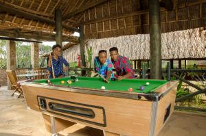 a group of three men playing a game of pool at Maneaters in Tsavo