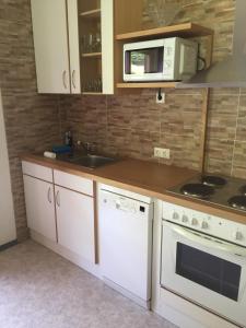 a kitchen with white cabinets and a sink and a microwave at Ferienhaus Ruggenthaler in Matrei in Osttirol