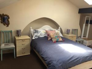 a bedroom with a bed with a headboard and pillows at 4c Belmont Terrace in Buxton