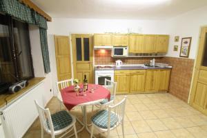 a kitchen with a table and chairs with a red table cloth at Penzion Na Kopečku in Velké Karlovice