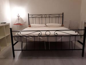 un letto nero con lenzuola e cuscini bianchi di L' Antico Comune a Cavriglia