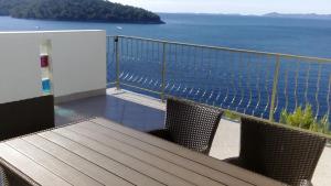 a balcony with a table and chairs and the ocean at Apartment Inter Vivos in Smokvica