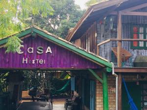 a building with a sign that reads casa hsie at CasaHostel Floresce in Praia do Rosa